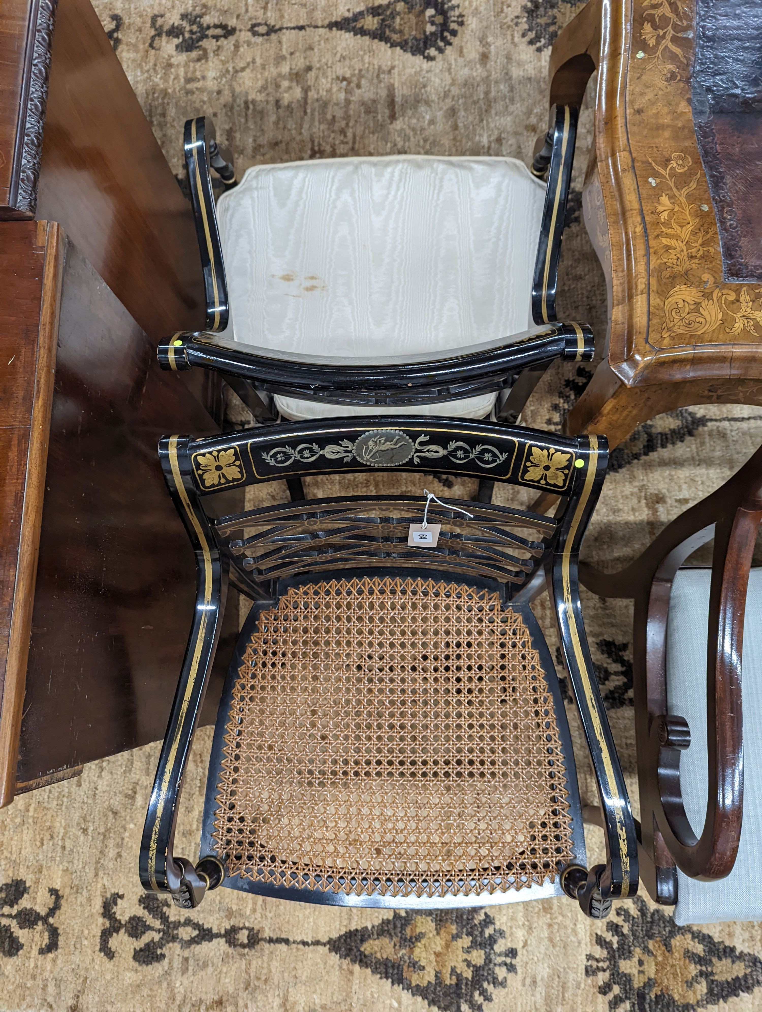A pair of Regency style painted cane seat elbow chairs, width 52cm, depth 47cm, height 84cm